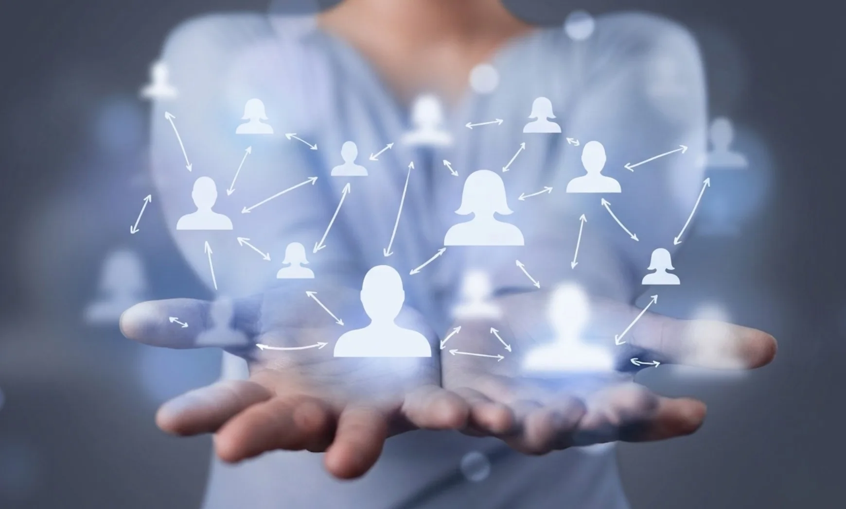 Cupped hands holding a glowing illustration of many connected people icons linked by arrows, representing a supportive communication network.