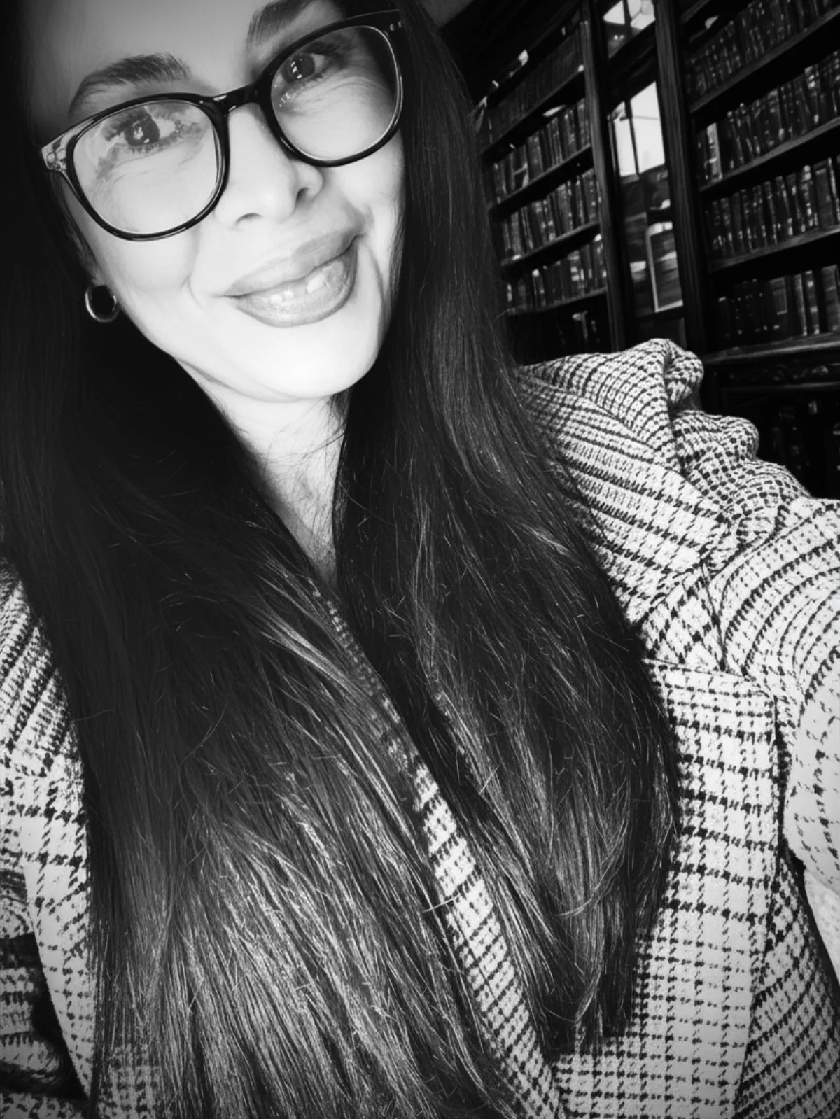 Portrait of Wendy Beck-Orlando, founder of Pandora's Box Sexual Health Rehabilitation, smiling in a library.